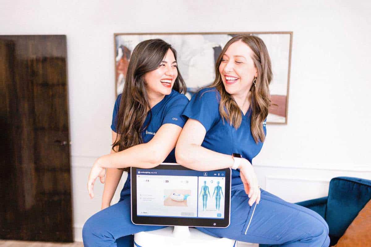 Jessie Poole and Jenn McGregor from Element Body Lab sitting on coolsculpting machine